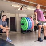 Coop and Jason Khalipa in a home gym deadlifting