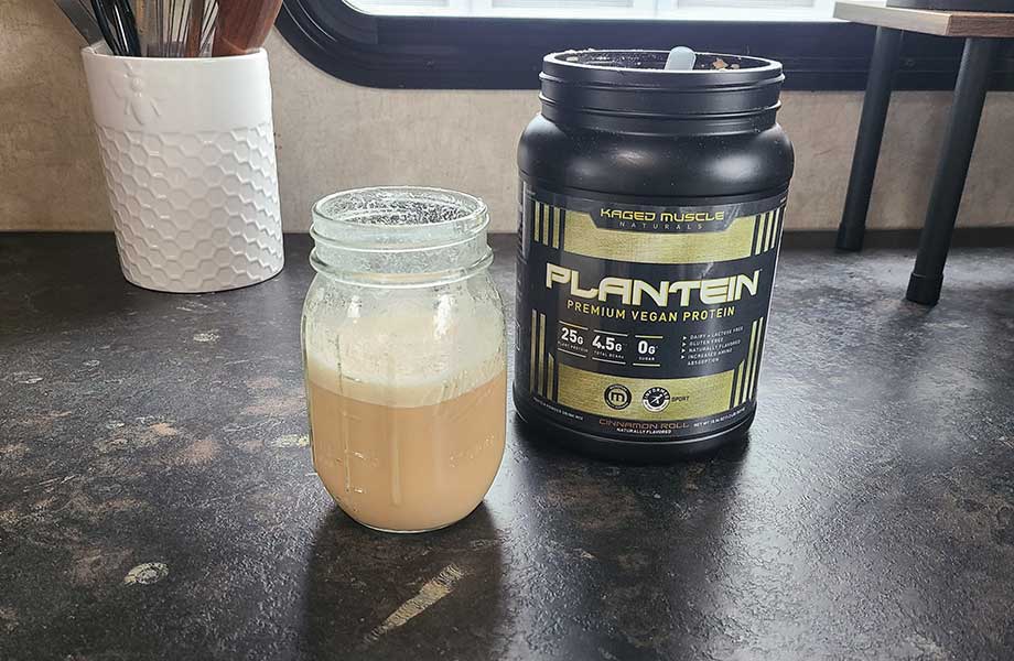 A jar half-filled with a Kaged Plantein shake is shown next to the prominently placed container