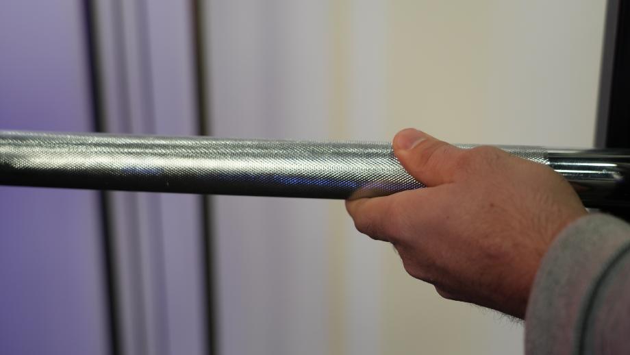Close up of Coop's hand as he examines the knurling on a RitFit Multifunctional Smith Machine.