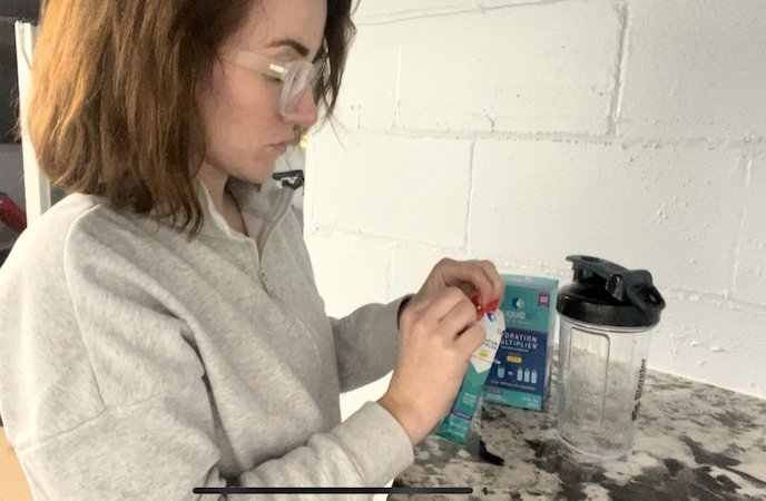 An image of a woman taking Liquid IV