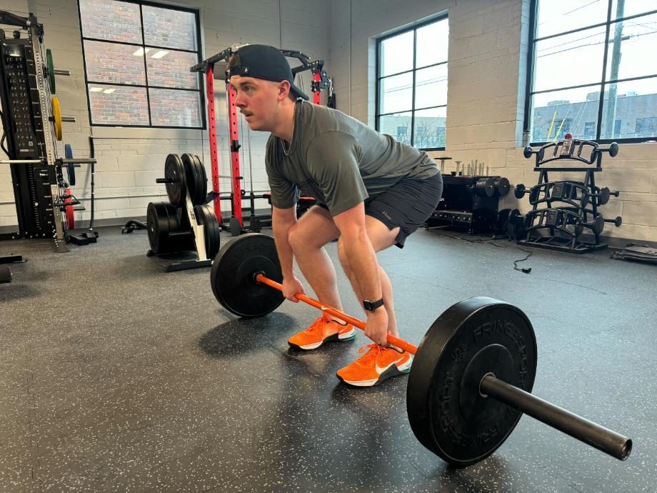 Man lifting a loaded barbell on Stamina Mats Gym flooring