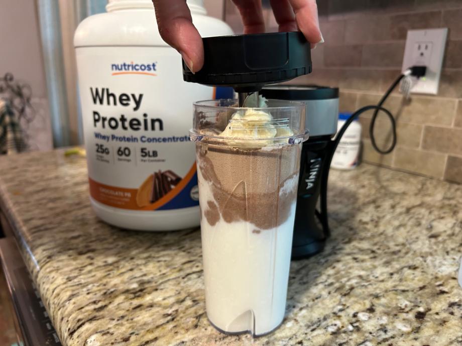 girl making smoothie with nutricost whey protein isolate