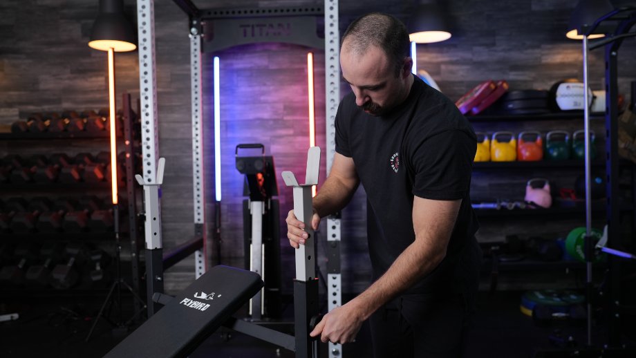 Coop adjusts the J-cup height on a FLYBIRD Olympic Weight Bench