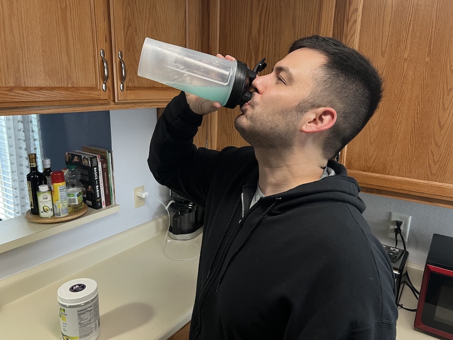 A person is shown drinking an IsoWhey protein shake.