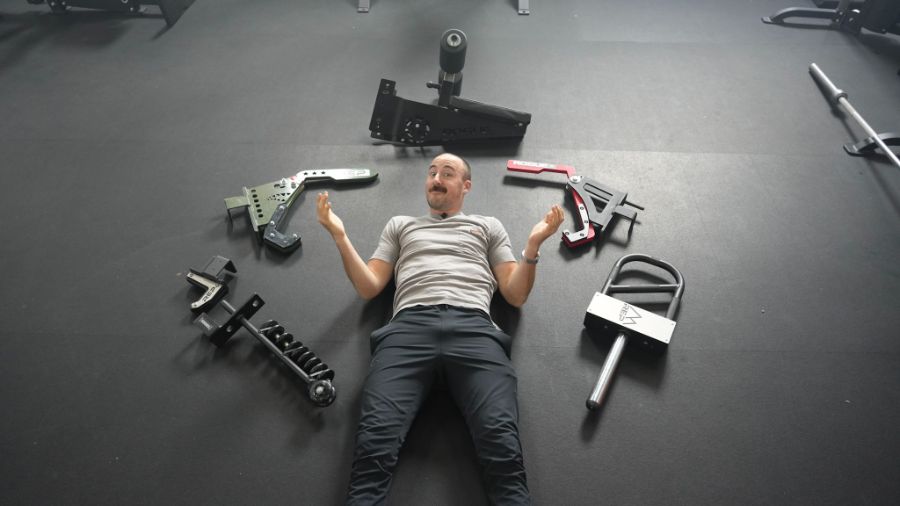 Man lying on the floor among various squat rack attachments