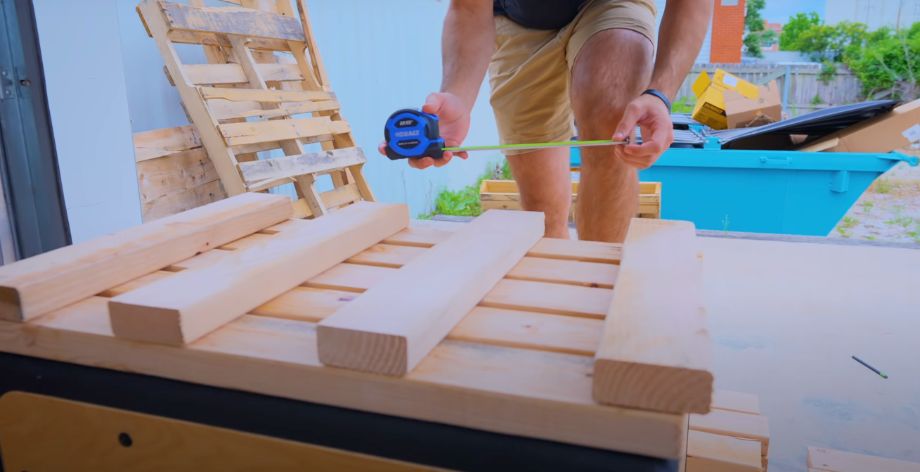 man measuring wood for diy pulling block