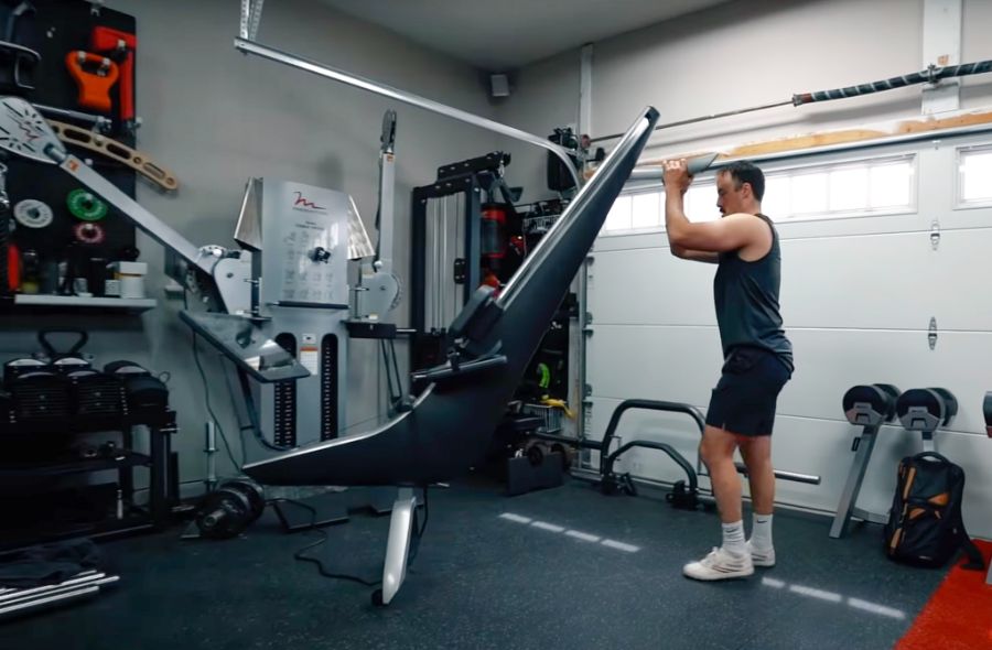 Man moving the Hydrow Rower in a garage gym