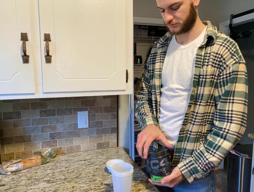 A man opens up a can of C4 Ultimate Pre-Workout