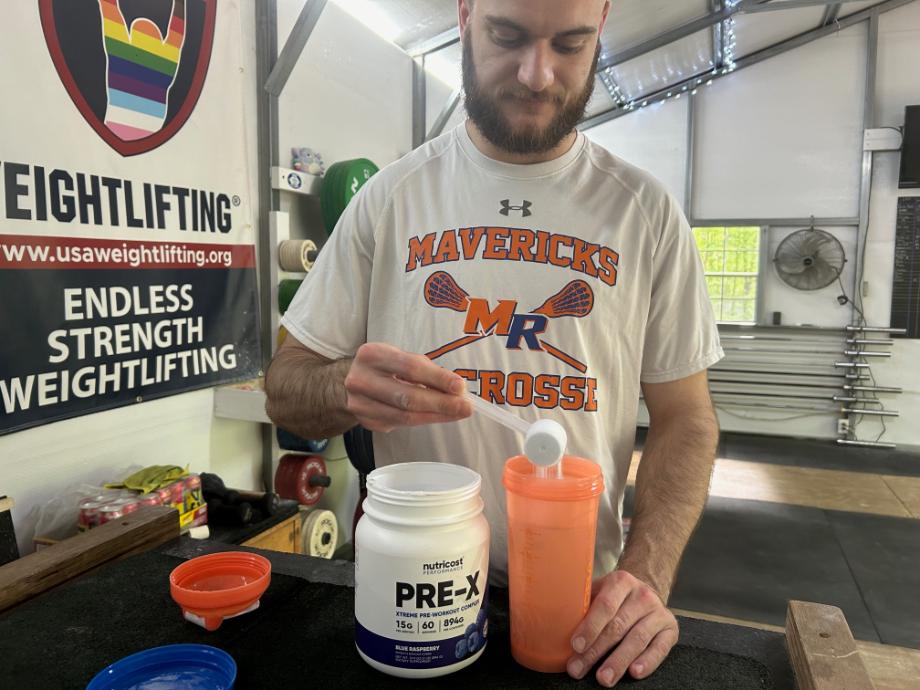 Man pouring Nutricost Pre-X Pre-Workout into a shaker cup
