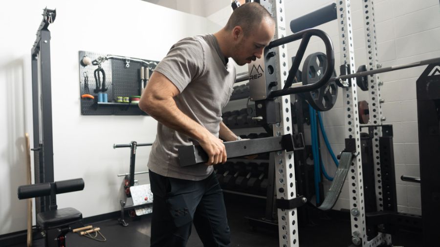 Man placing a spotter arm on a power rack