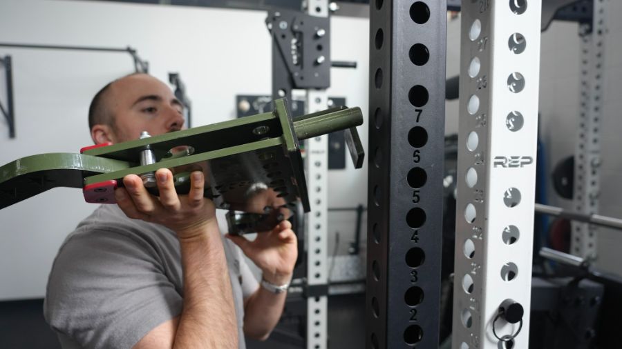 Man placing a rack attachment on a power rack