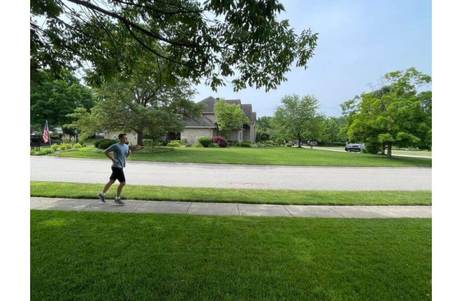 Zoomed out view of a man running down the sidewalk