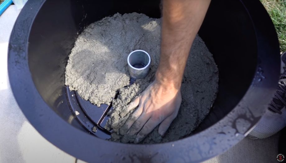 Man smoothing concrete for DIY weight plate