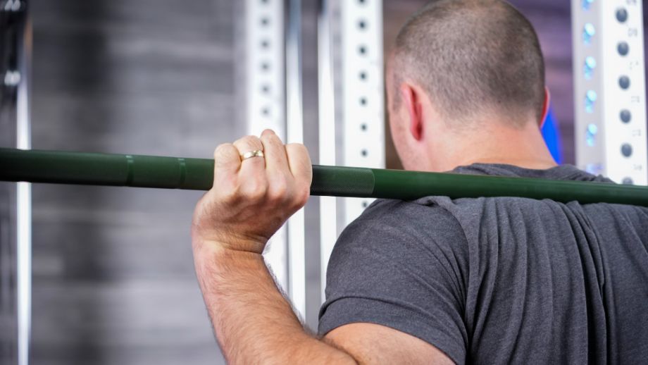 Man squatting with the REP Colorado Bar