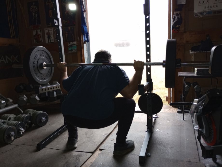 Man squatting on the Fitness Reality 810XLT