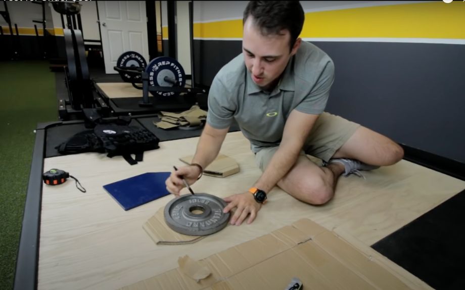 Man tracing plates for DIY weight vest
