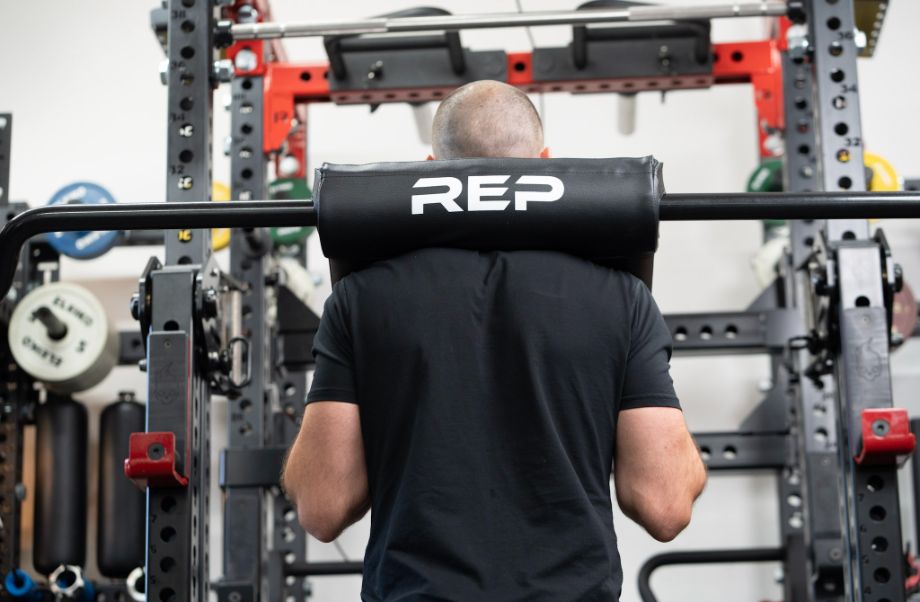 Man with the REP Fitness Safety Squat Bar on his back