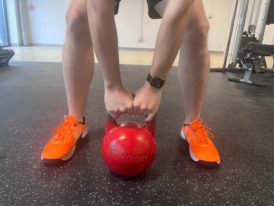 man holding onto titan fitness kettlebell