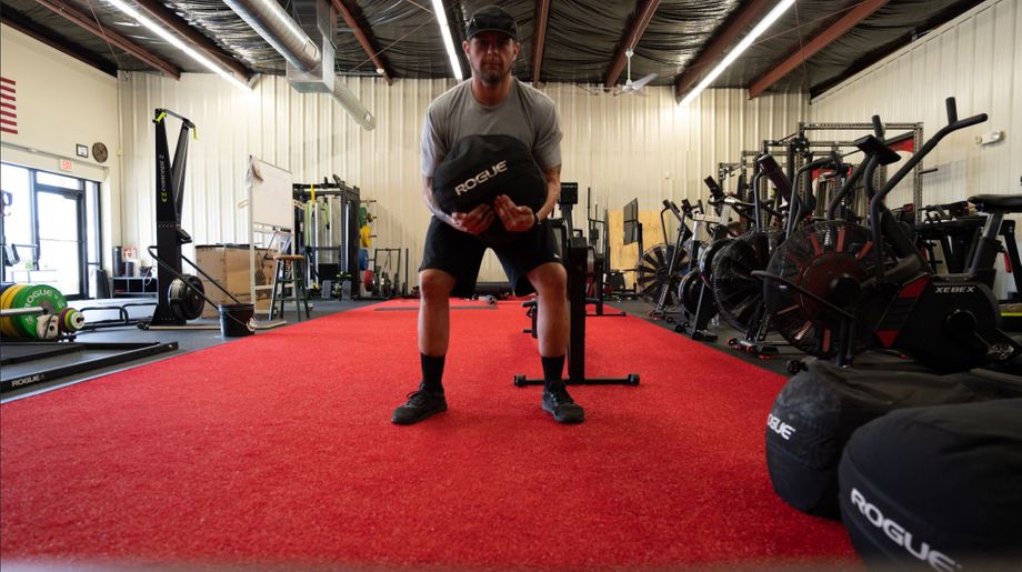 Mike using the Rogue Strongman sandbag during a workout