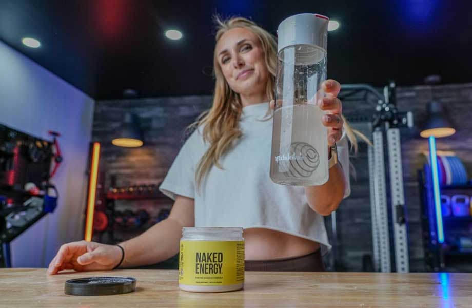 Woman holding bottle of Naked Pre-workout