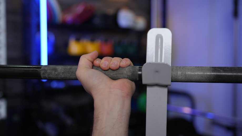 Close look at coop gripping a barbell on the FLYBIRD Olympic Weight Bench.