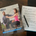 NASM textbook and notebook on a desk