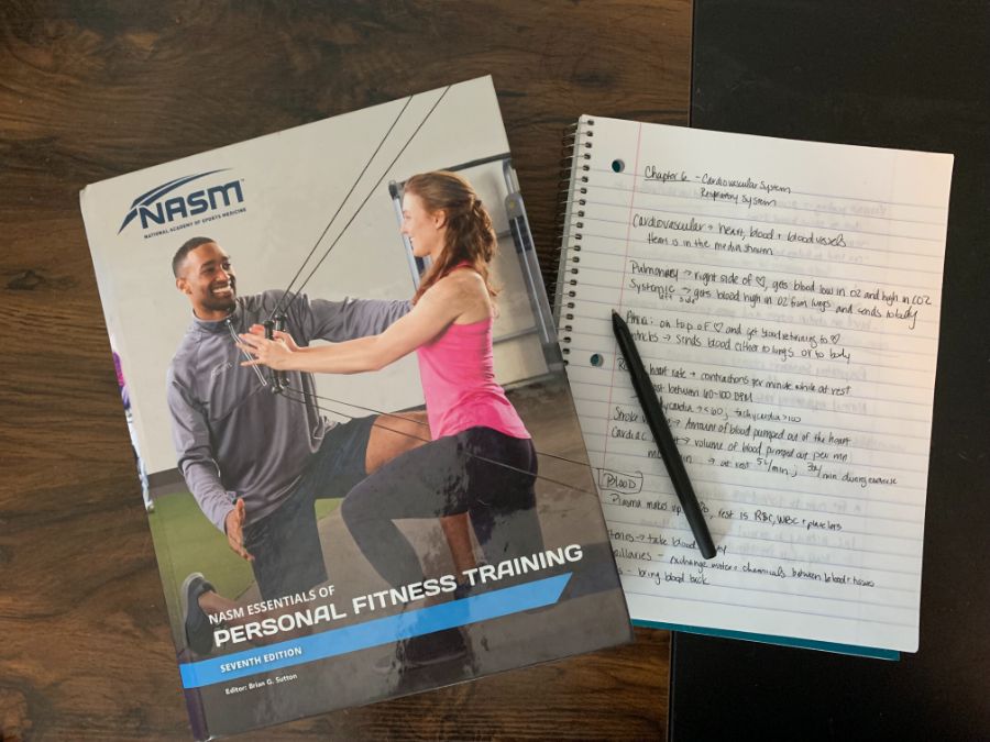 NASM textbook and notebook on a desk