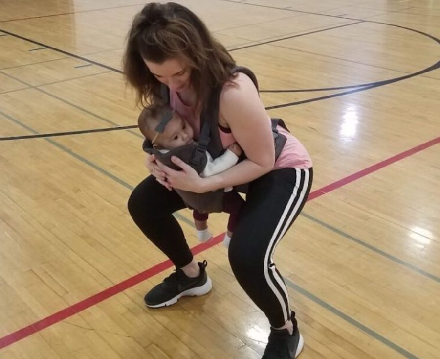 Woman holding her daughter while she squats