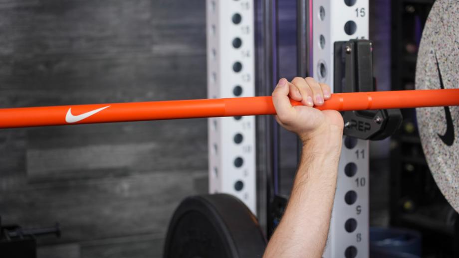 Man doin bench press with the Nike barbell and bumper plates