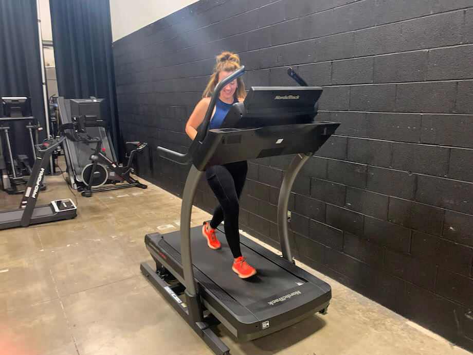 An image of a woman running on a NordicTrack X22i Treadmill