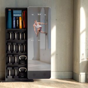 Product image of the NordicTrack Vault showing a workout on the reflective screen, with dumbbells and kettlebells stored on the attached shelving.