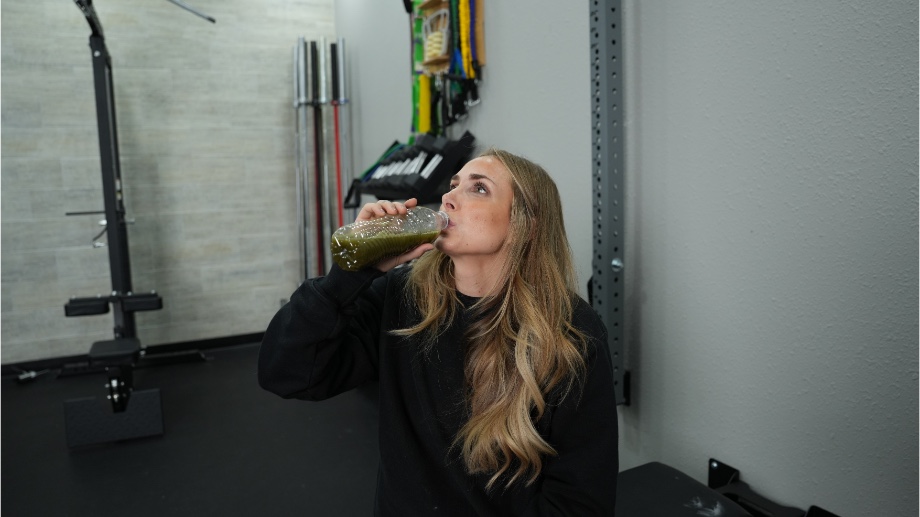 An image of a woman drinking Onnit Shroom Tech Greens