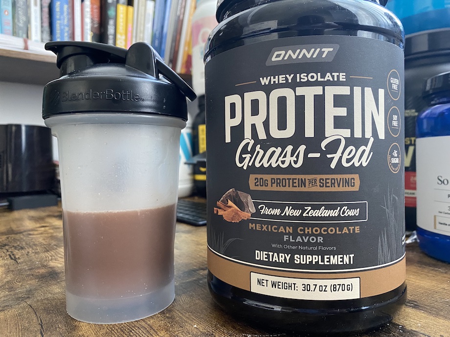 An image of Onnit grass-fed whey protein powder container and shaker bottle