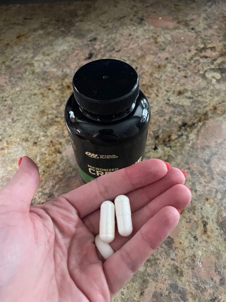 Optimum Nutrition creatine capsules in a woman's hand