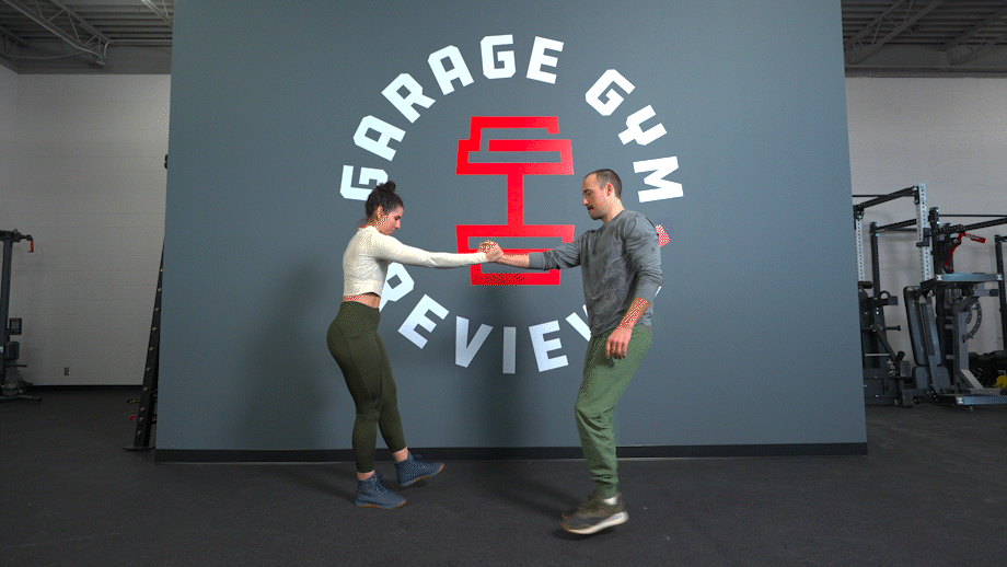 Two people demonstrating partner single-leg squats