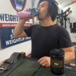 Person drinking Alpha Lion Superhuman Pre-Workout in a gym