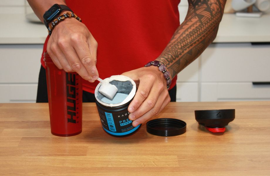 Person holding scoop of Kaged Pre-Workout Sport