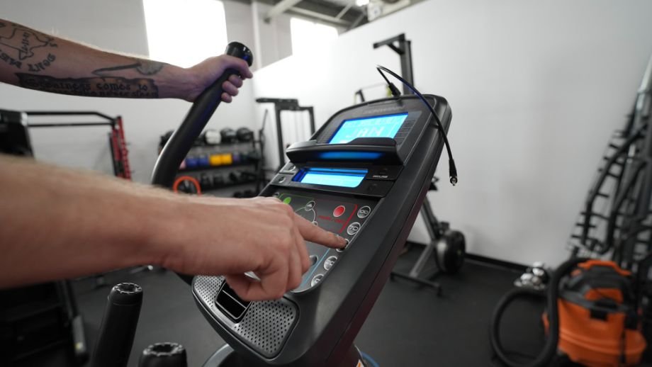 person navigating console of schwinn 470 elliptical