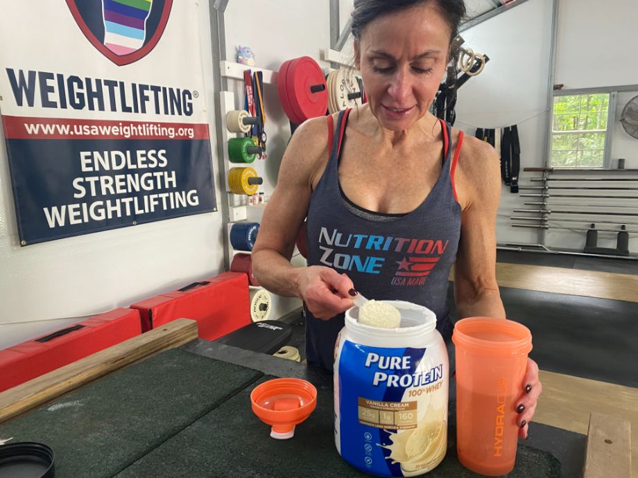 Person measures Pure Protein into a shaker bottle