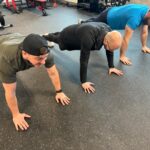 Three guys planking in a gym with Stamina mats gym flooring