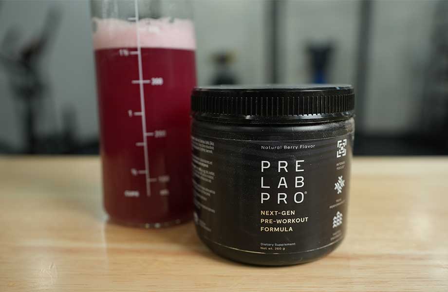 A frothy, red shake rests just behind a prominently placed container of Pre Lab Pro pre-workout.