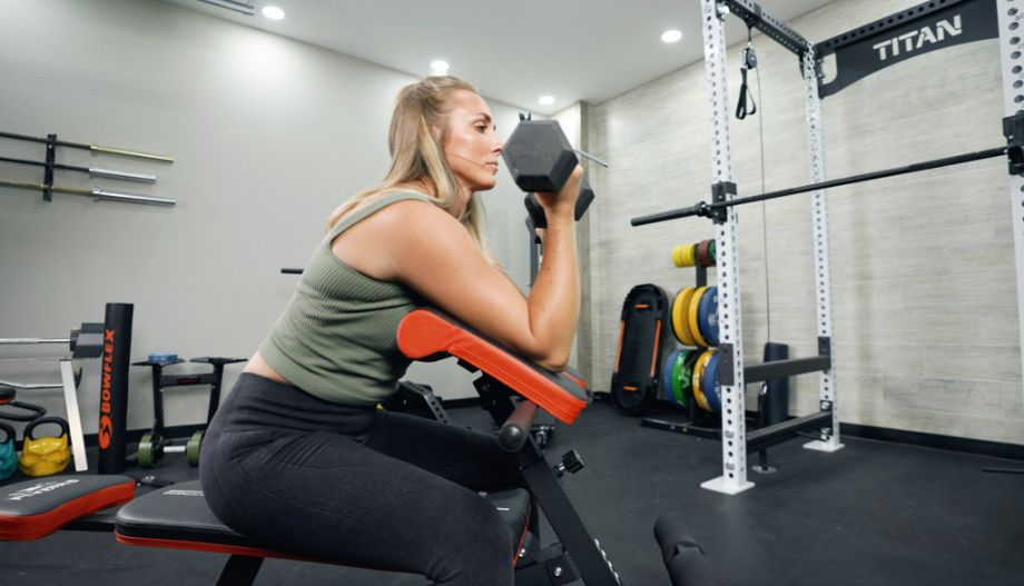 Woman doing preacher curls on the Flybird Roman Chair