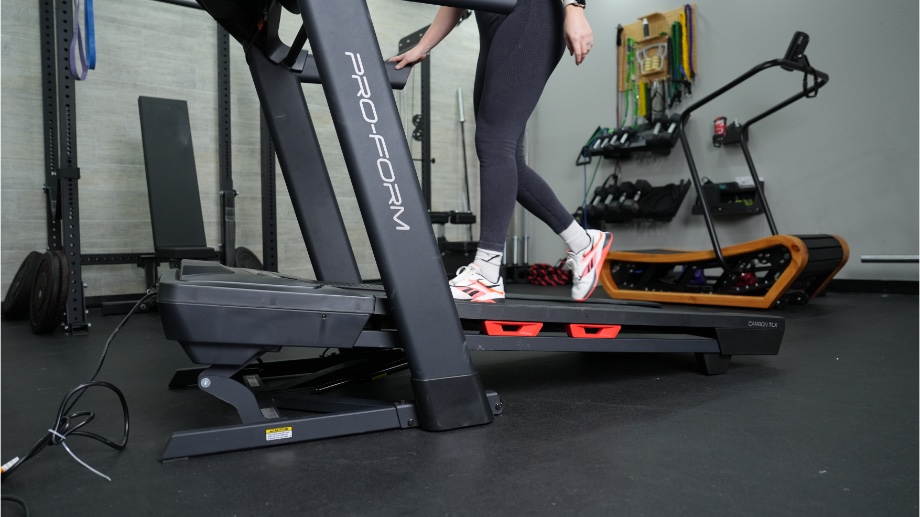 An image of a woman walking on the ProForm TLX treadmill at an incline