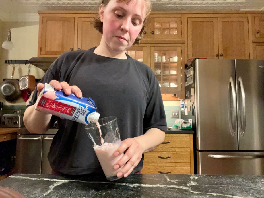 Woman pouring the Pure Protein Shake into a glass