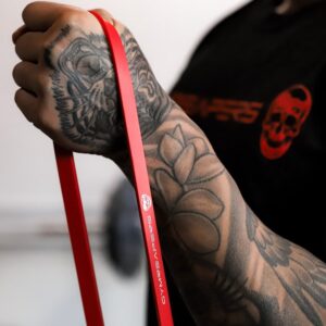 Person using red Gymreapers Resistance Band around hand.