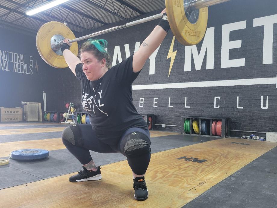 A weightlifter performs an overhead squat while wearing Reebok Lifter PR 3 shoes. 