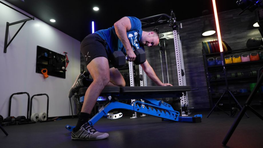 Man performing one-arm dumbbell rows on the REP Fitness Blackwing