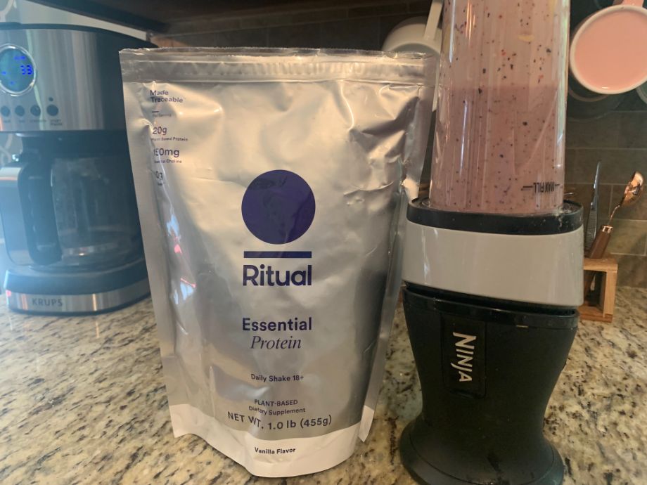 ritual essential shake 18+ in blender next to bag