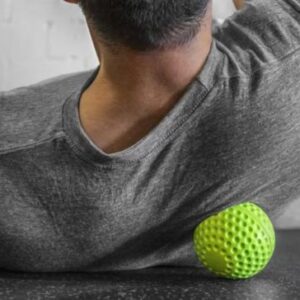 An image of a man using Rogue's dimple ball on his upper back