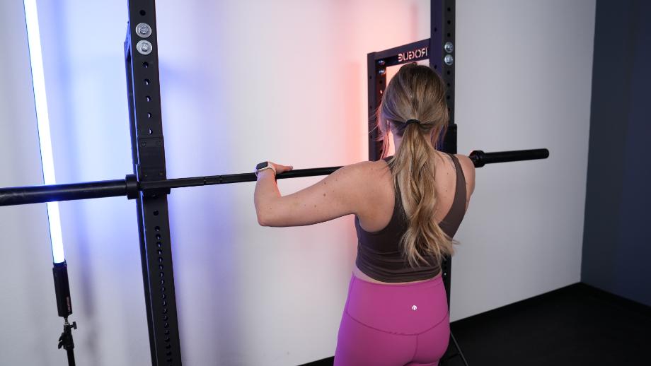 Woman with a barbell placed on the Rogue HR-2 Half Rack